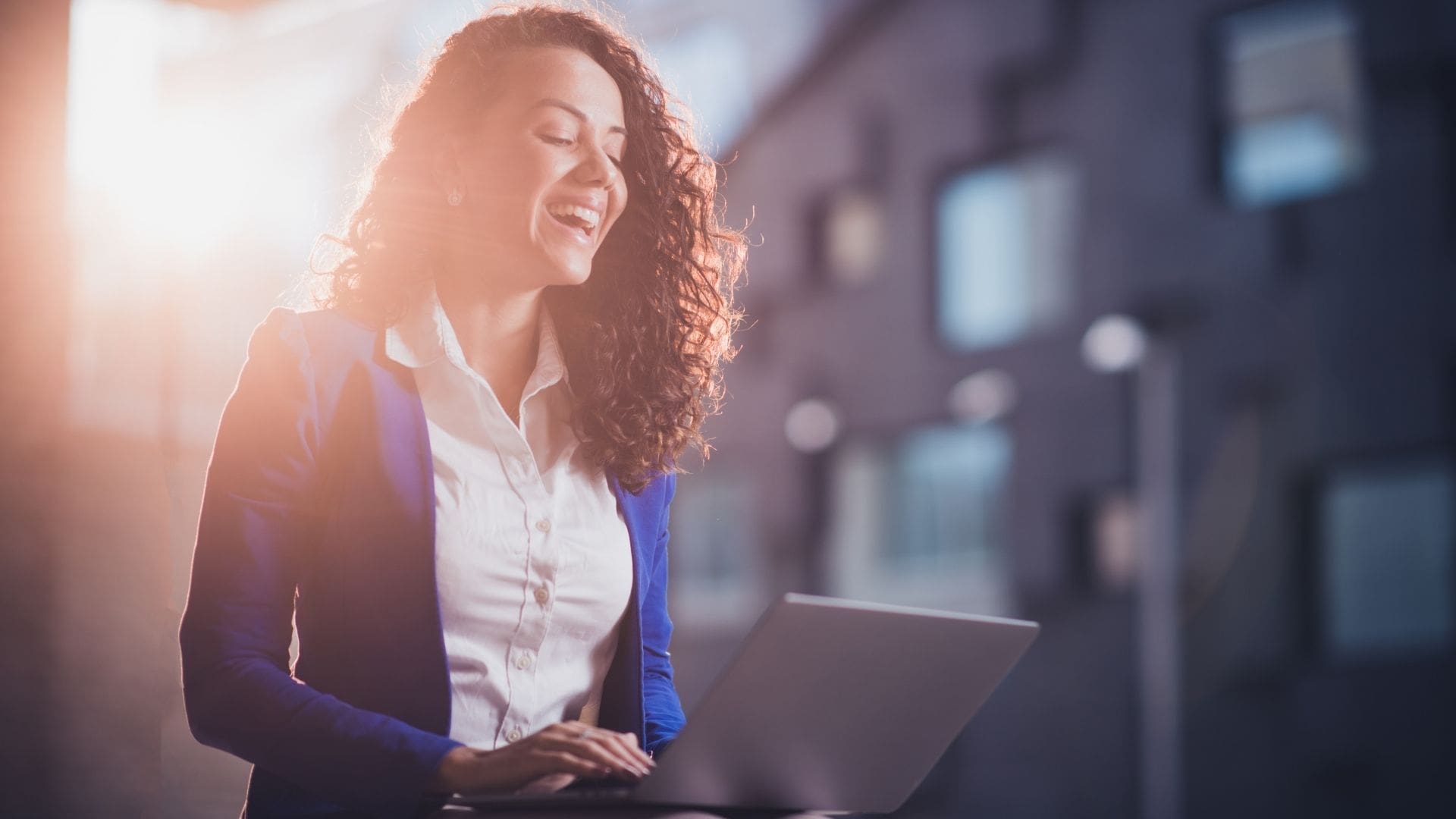 Woman excitedly reading email on her laptop