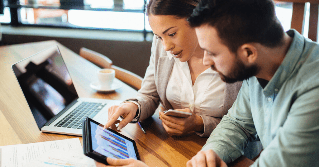 Two employees review customer community analytics